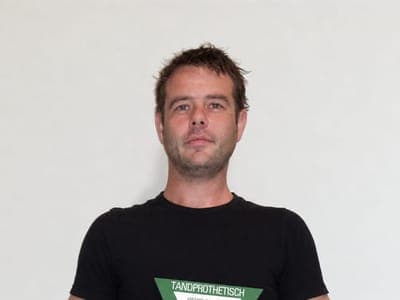 Thijs houdt het schild van het Nederlands Tandprothetisch Instituut vast: gediplomeerd tandprotheticus, registratienummer 593